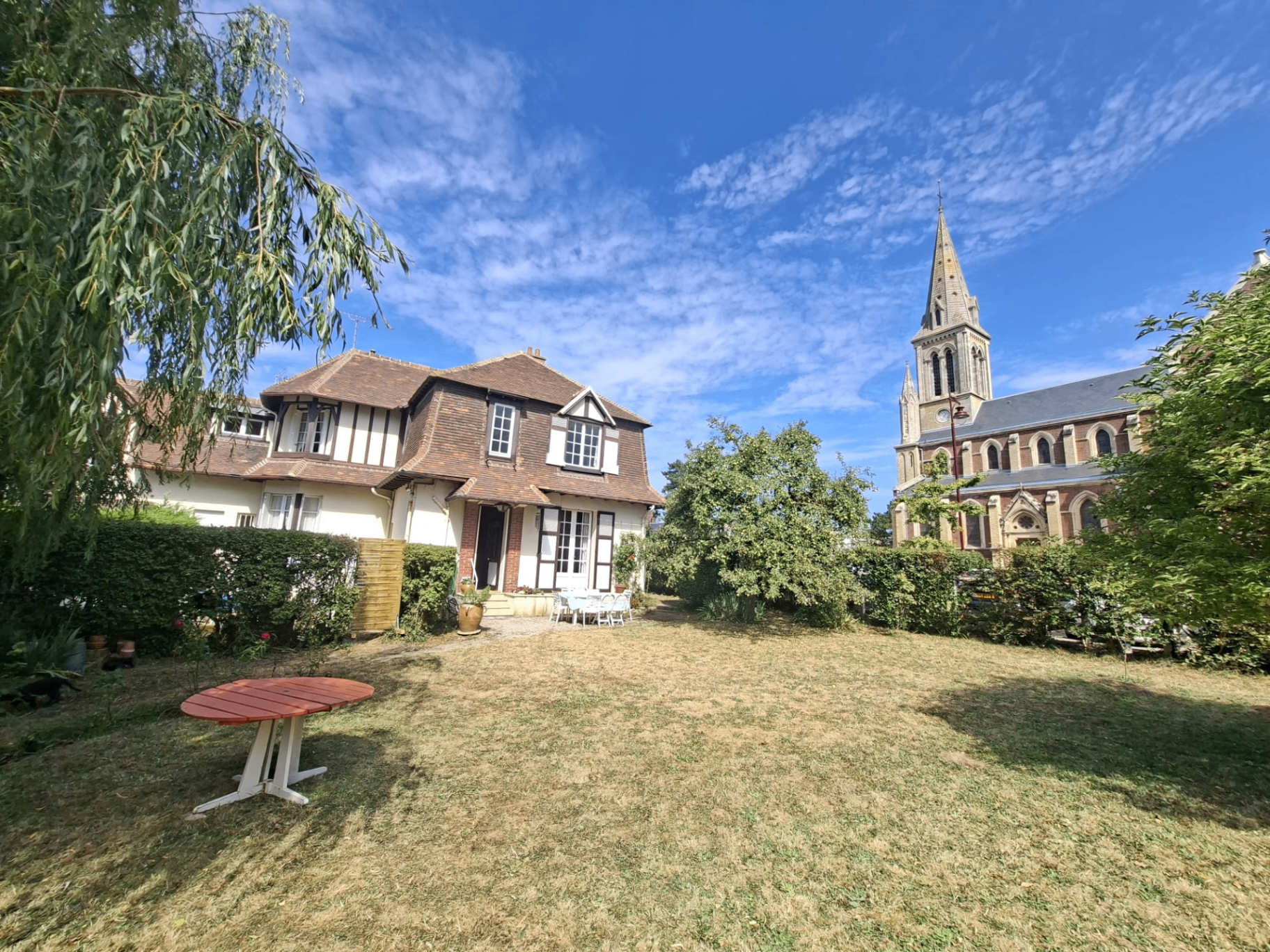 Jardin avec vue sur la maison et l'église